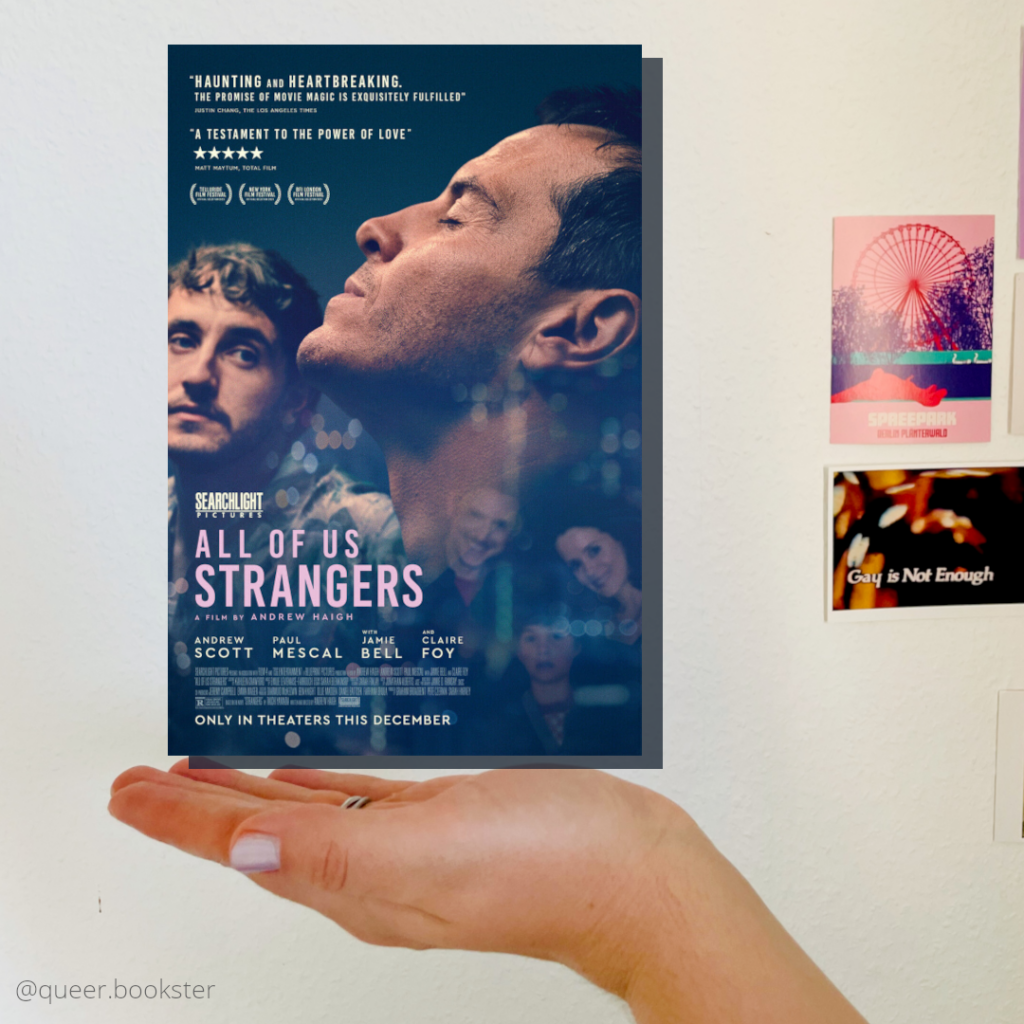 Eine Hand hält das Filmplakat von »All of Us Strangers« vor einer Wand mit Postkarten